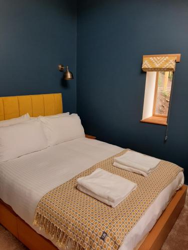 a bedroom with a bed with two towels on it at The Glasshouse in Ilfracombe
