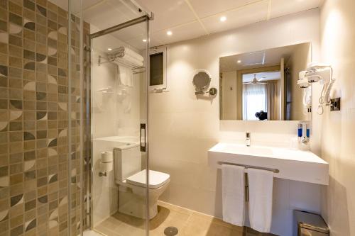 a bathroom with a toilet and a sink and a shower at Hotel Zeus in Málaga