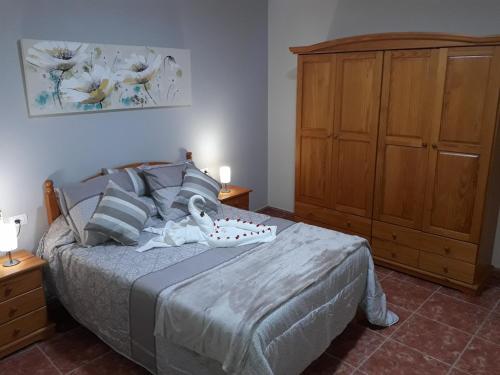 een slaapkamer met een bed en een houten kast bij Casa los abuelos 1 in La Goleta