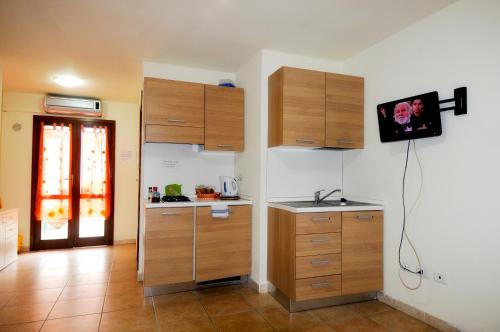 a kitchen with wooden cabinets and a counter top at Il Sogno di Alghero - Adults Only in Alghero