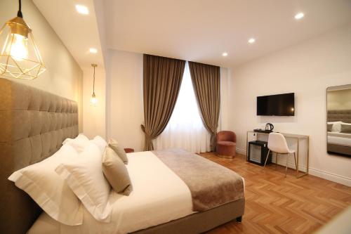 sypialnia z łóżkiem, biurkiem i telewizorem w obiekcie B&B Villa Sant'Elmo con parcheggio interno w mieście Neapol