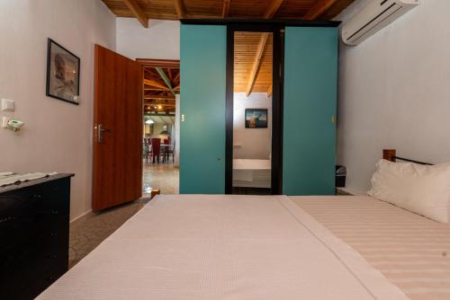 a bedroom with a large bed with blue walls at Front Beach House in Skala Kallirakhis