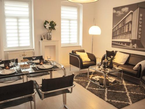- un salon avec un canapé, une table et des chaises dans l'établissement BAUHAUS Design-Luxus Apartment, 20er Jahre Stil, Garten, à Gera