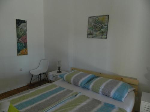 a bedroom with a bed and a chair in it at Apartments Vila Palma in Medulin