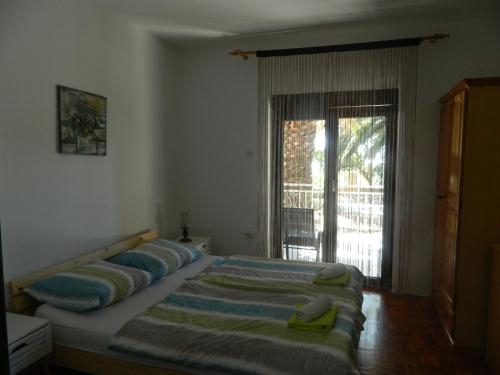a bedroom with a bed with pillows and a window at Apartments Vila Palma in Medulin