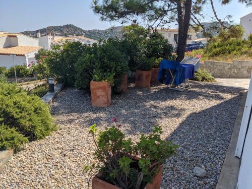 a garden with potted plants and a table and chairs at La Vista in Port de la Selva