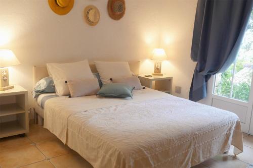 a bedroom with a bed with two lamps and a window at Lou Candelou in Grasse