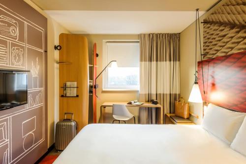 um quarto de hotel com uma cama e uma secretária em ibis Hotel Muenchen City West em Munique