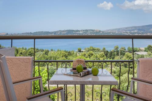 a table on a balcony with a view of the water at Panorama Fanari studios and apartments in Argostoli