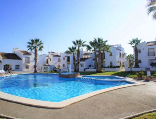 een groot zwembad voor een aantal huizen bij Bungalow Los Dolses in Orihuela