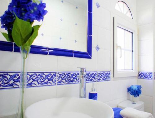 een badkamer met een vaas met blauwe bloemen bij Bungalow Los Dolses in Orihuela