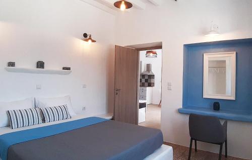 a white and blue bedroom with a bed and a chair at Bella Vista in Panteli