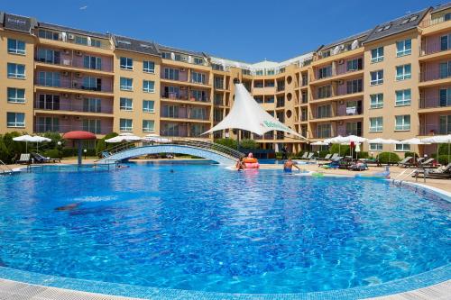 duży basen przed niektórymi budynkami w obiekcie Pollo Resort w Słonecznym Brzegu