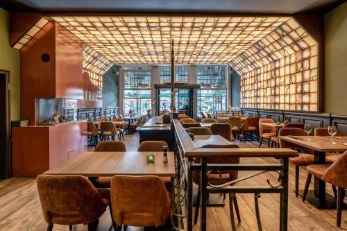 a restaurant with tables and chairs and a large window at Hotel Central in Bruges