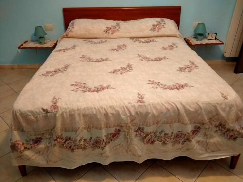 a bed with a pink bedspread with flowers on it at Agriturismo I due Falcetti in Castelfiorentino