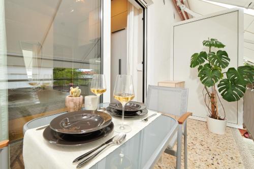 - Mesa de comedor con 2 copas de vino blanco en Rooms Izidoro Gasparini, en Umag