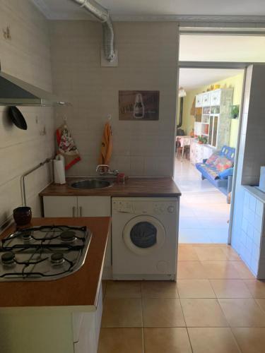 a kitchen with a stove and a washing machine at Casa LEON in León