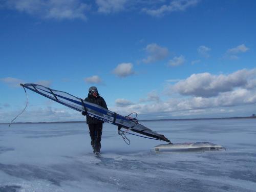 a man walking on the beach holding a surfboard at Nowe Guty Fun in Nowe Guty
