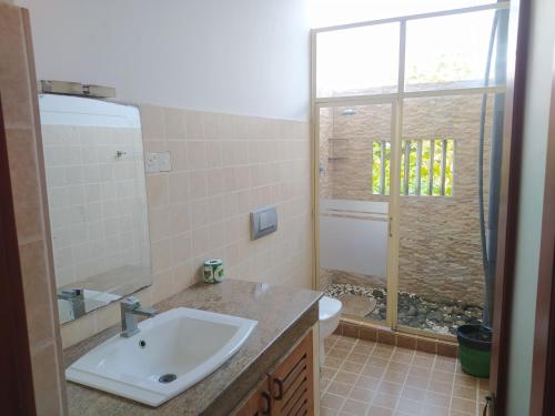 a bathroom with a sink and a toilet and a shower at The Residence Bentota in Bentota