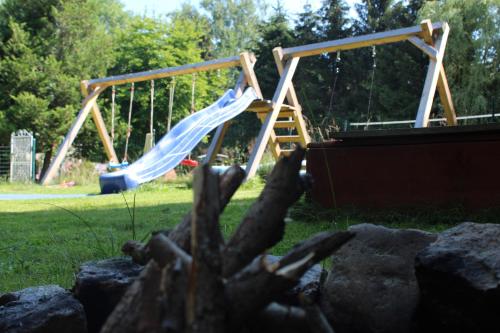 a boy on a slide in a playground at Noclegi Różanka in Radomierz