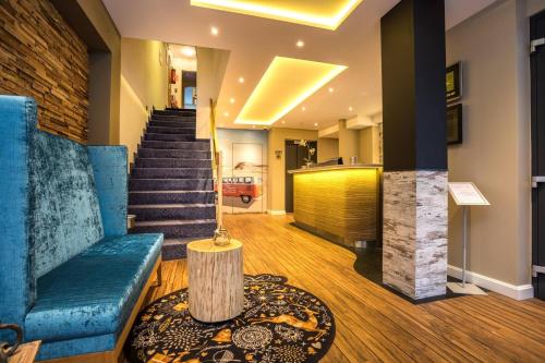 a lobby with a blue couch and a staircase at Hotel Restaurant Ennen in Norderney