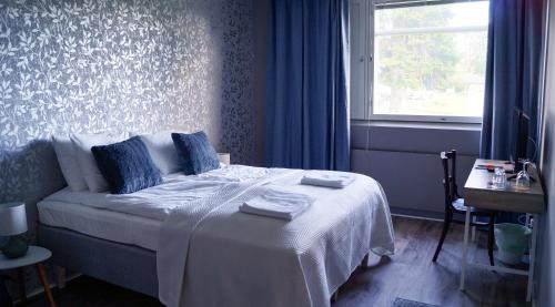 una camera da letto con un letto con una coperta bianca e una finestra di Kartanomajoitus Sofia & Angelique a Pieksamaki