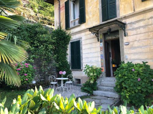 a table and chairs in front of a building at B&B Villa le Ortensie in Faggeto Lario 