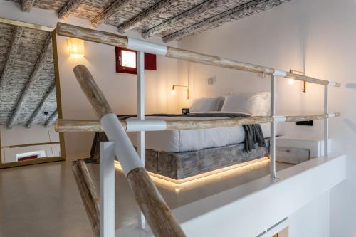 a loft bed in a room with a bed in it at The TownHouse Mykonos in Mikonos