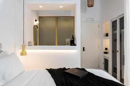 a bedroom with a bed with a book on it at The TownHouse Mykonos in Mikonos