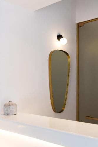 a mirror on a wall next to a shelf at The TownHouse Mykonos in Mikonos