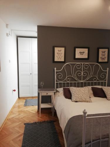 a bedroom with a bed with a gray wall at Juli's Place in Rovinjsko Selo