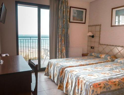 ein Hotelzimmer mit einem Bett und einem großen Fenster in der Unterkunft Hotel Marian Platja in Roses