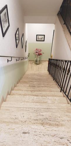 a hallway with a staircase with a vase of flowers at Hotel Gäubodenhof in Straubing