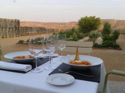 
a table topped with plates of food and wine glasses at Hotel Aire de Bardenas in Tudela
