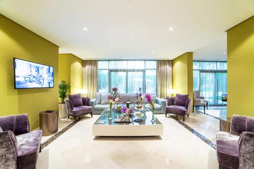a living room with yellow walls and a table with flowers on it at Vivienda Hotel Villas Granada in Riyadh