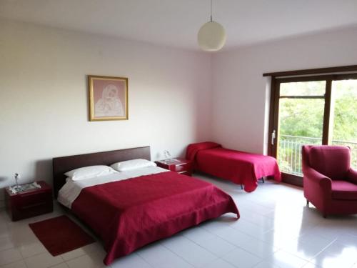 sypialnia z 2 łóżkami, krzesłem i oknem w obiekcie Appartamento Perito w mieście Perito