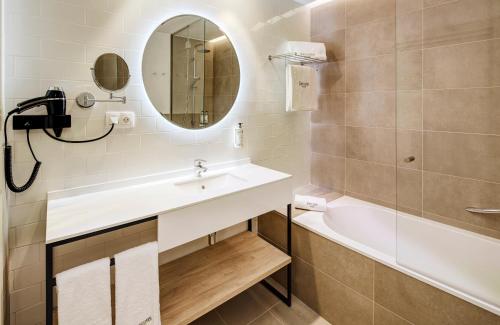 uma casa de banho com um lavatório, uma banheira e um espelho. em Sercotel Ayala em Bilbao