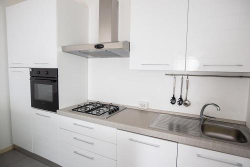 a white kitchen with a stove and a sink at Griante suites in Griante Cadenabbia