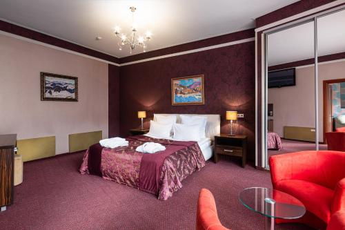 Pokój hotelowy z łóżkiem i czerwonym krzesłem w obiekcie Bukovel Apart w mieście Bukowel