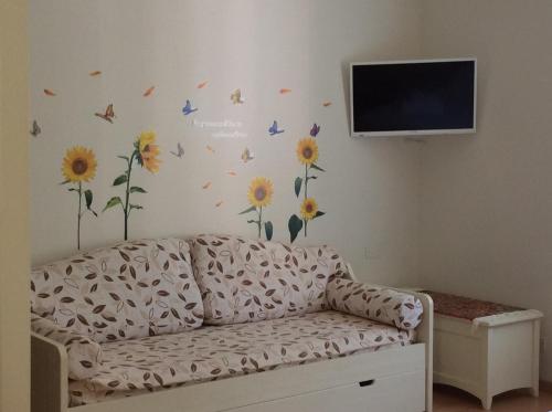 a living room with a couch with flowers and butterflies on the wall at Ca Lorelei in Riomaggiore
