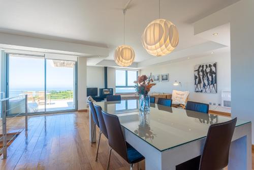 a dining room and living room with a table and chairs at Casas da Pescaria A in Nazaré