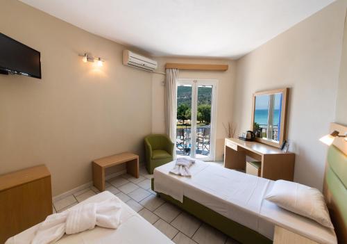 a hotel room with two beds and a window at Surf Hotel in Vasiliki