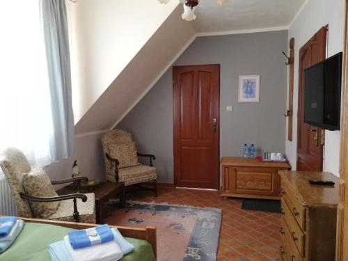 a living room with a bed and a tv at Siedlisko Sabinowo in Węgorzewo