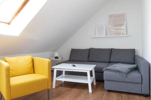 een woonkamer met een bank en 2 stoelen bij Ferienwohnung Quedlinburg Harz in Quedlinburg