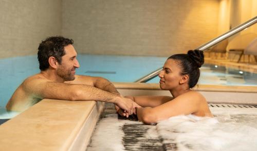 a man and a woman in a hot tub at CitySuites Aparthotel in Manchester