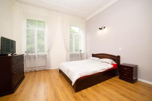 - une chambre avec un lit, une commode et 2 fenêtres dans l'établissement Lviv City Rent, à Lviv