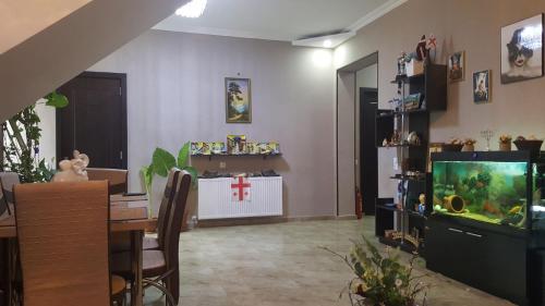 a living room with a dining table and a fish tank at Guesthouse different in Tbilisi City
