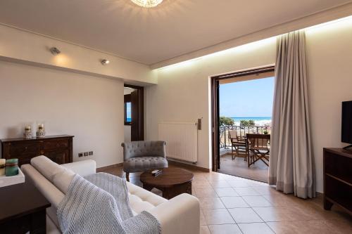 a living room with a couch and a table and a television at Kahlua Bay Apartments in Hersonissos