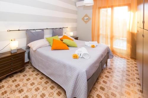 ein Schlafzimmer mit einem Bett mit orangefarbenen und grünen Kissen in der Unterkunft MAGIC ON THE LAKE - Panoramic in Marone