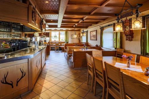 un restaurante con mesas y sillas de madera y un bar en Burggasthof Hauptmann, en Kollnburg